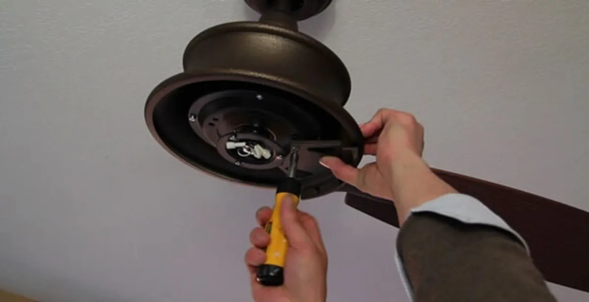 Electrician installing ceiling fan mounting bracket and fixture in Savannah, GA