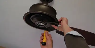 Electrician installing ceiling fan mounting bracket and fixture in Savannah, GA
