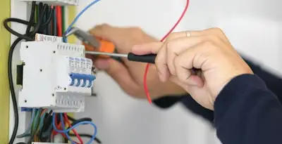 Electrician installing and adjusting circuit breakers in an electrical panel in Savannah, GA