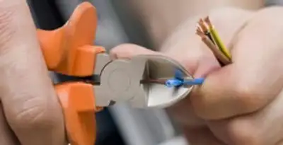 licensed electrician performing precise wire cutting and preparation during electrical service in Savannah, GA