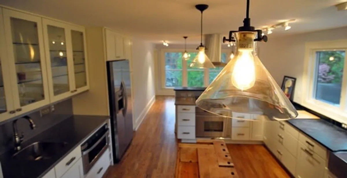 Residential electrician installing modern indoor light fixture in a home in Savannah, GA