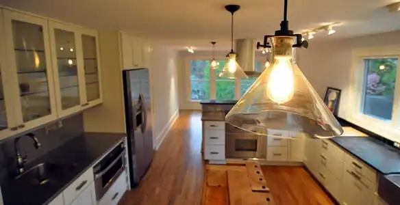 Residential electrician installing modern indoor light fixture in a home in Savannah, GA
