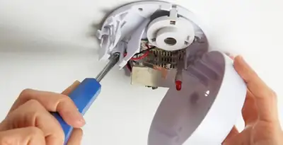 Certified technician wiring smoke detector during installation in Savannah, GA